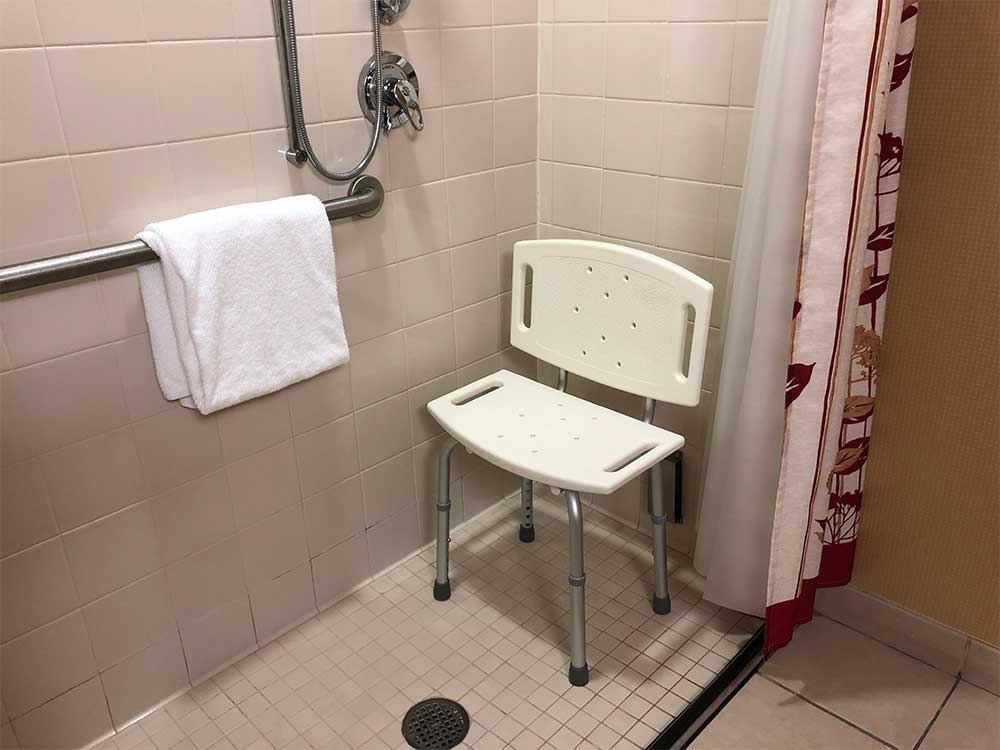 Roll-in shower with plastic shower chair.